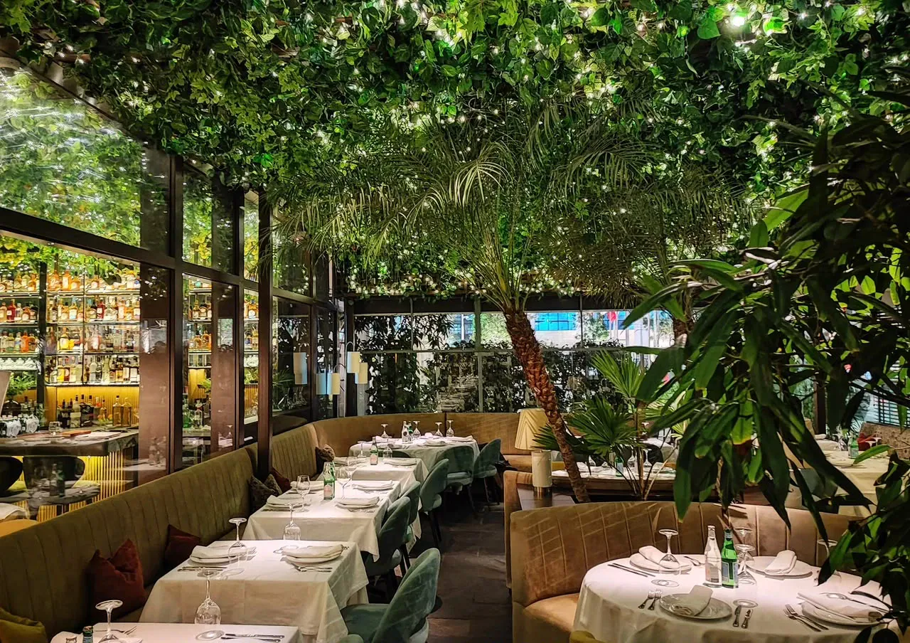Sal&oacute;n de Anima e Cuore con techo de plantas, luces y cava de vinos
